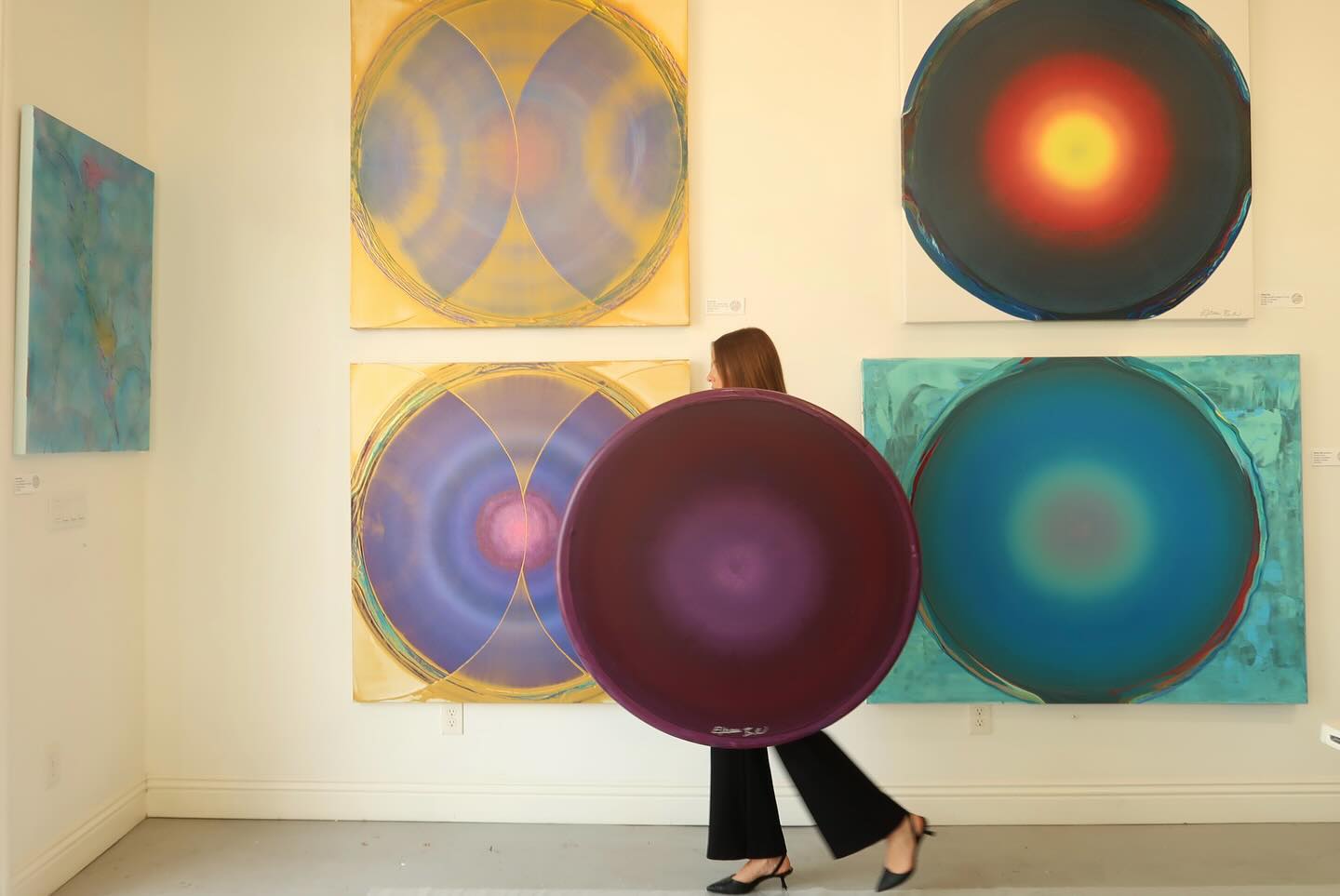 Gallerist carrying a circle through the gallery