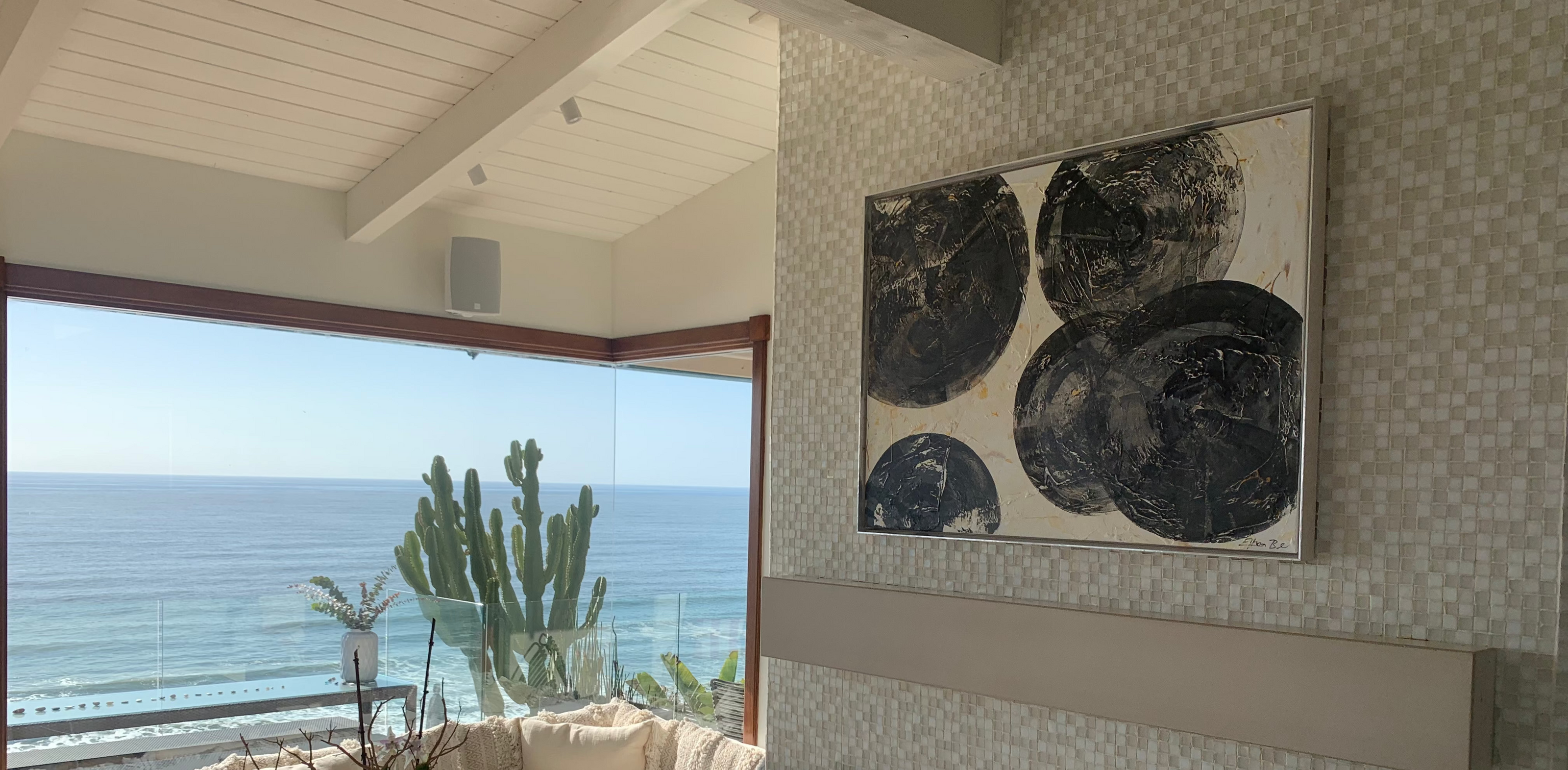 Living room with ocean view, sofa, coffee table, and wall art. Modern Ethan Blu Wall Art 
