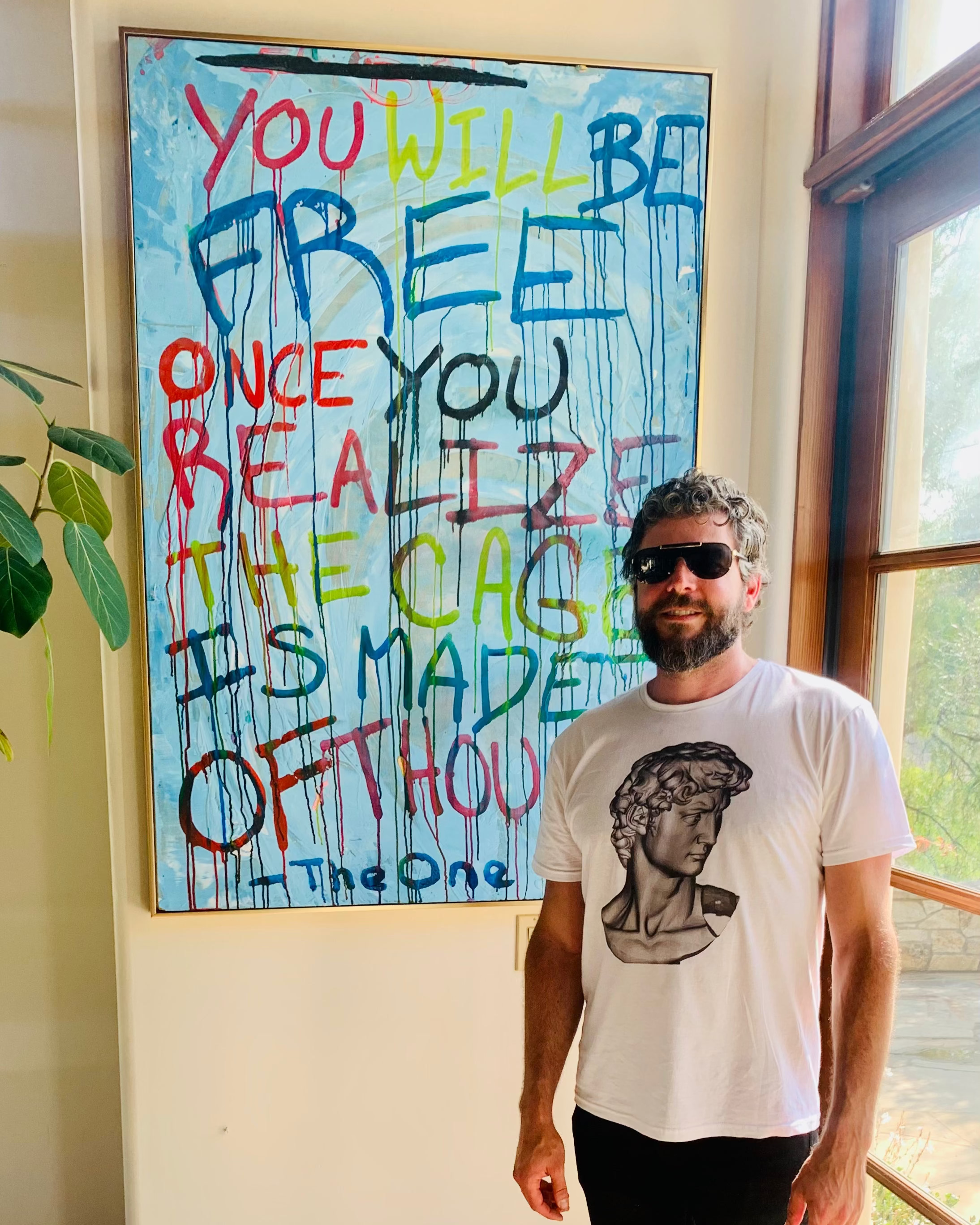 Ethan Blu standing in front of a motivational poster 